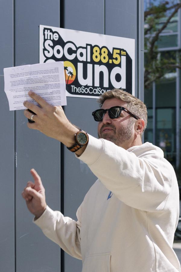 EVAN LOVETT LAINAMINUTE IN FRONT OF THE SOCAL SOUND LOGO